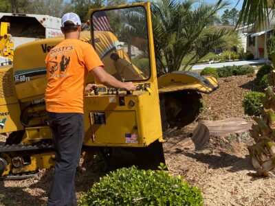 Dusty, owner of Dusty's Tree Service uses a stump grinder to remove a stump in the front yard of a home in rainbow springs dunnellon florida